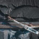 Top view of modern industrial machinery working with black natural coal in daylight
